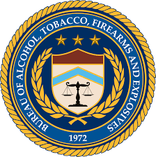 Seal of the Bureau of Alcohol, Tobacco, Firearms and Explosives featuring scales of justice, a shield, stars, and laurel leaves.