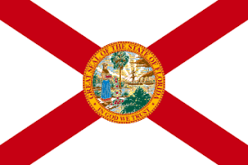 The flag of Florida featuring a red cross on a white field with the state seal in the center.
